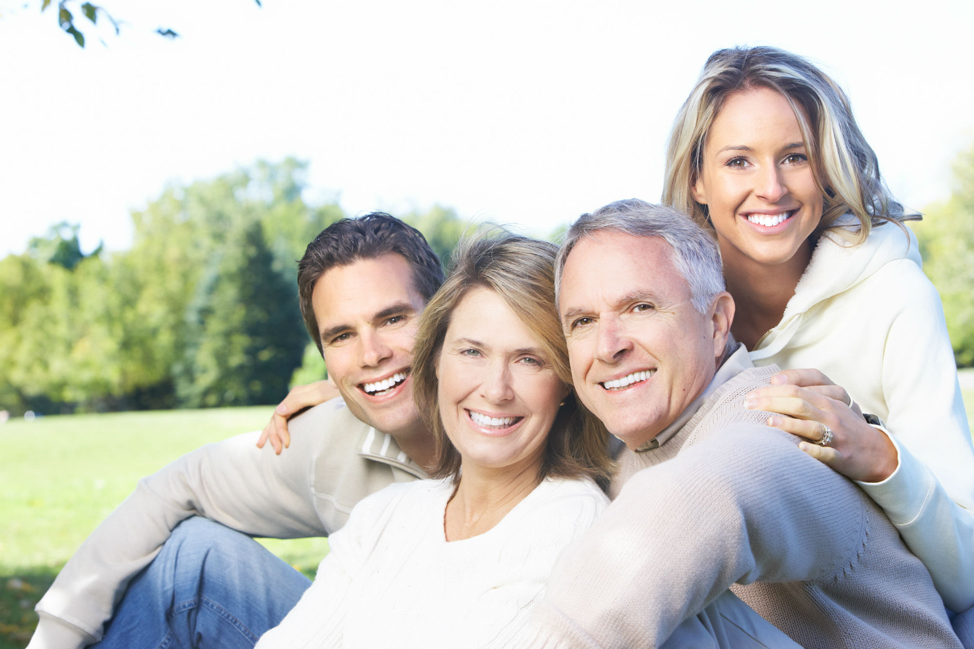 older family smiling in a field